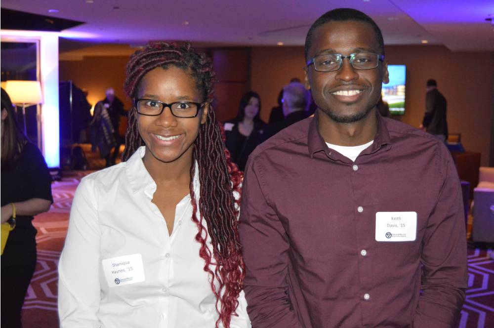 Two alumni smile for a photo together at the Chicago Alumni Reception